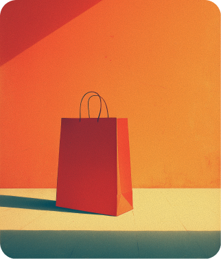Red paper shopping bag with black handles casting shadow on light-colored floor against a warm orange wall.