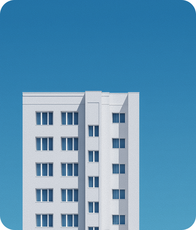 White multi-story building with numerous windows against a clear blue sky.