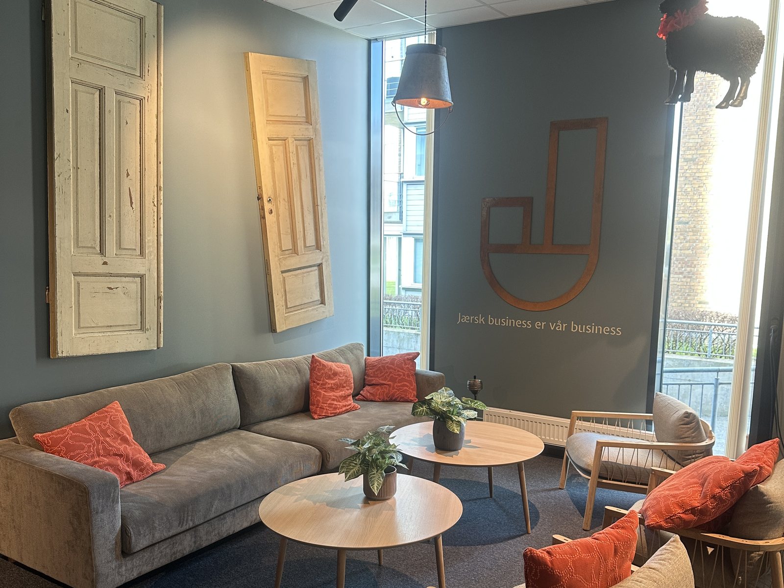 Lounge i Forum Jæren med sofaer, gamle dører på veggen og teksten «Jærsk business er vår business»