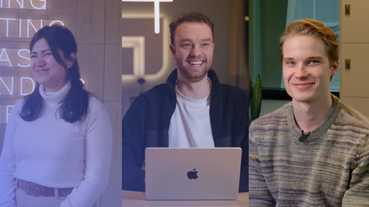 Three people smiling, with a woman in a white turtleneck on the left, a man with a laptop in the middle, and a man in a striped sweater on the right.