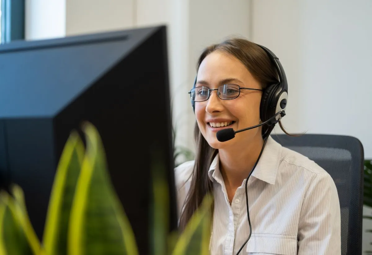 Une Sales Development representative qui sourit et porte un casque 