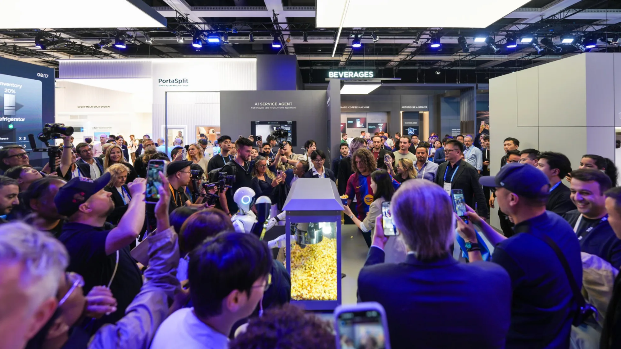 Dicht gedrängtes Publikum am Midea-Stand auf der IFA Berlin 2026 vor einer Popcorn-Maschine, an der ein Roboter serviert