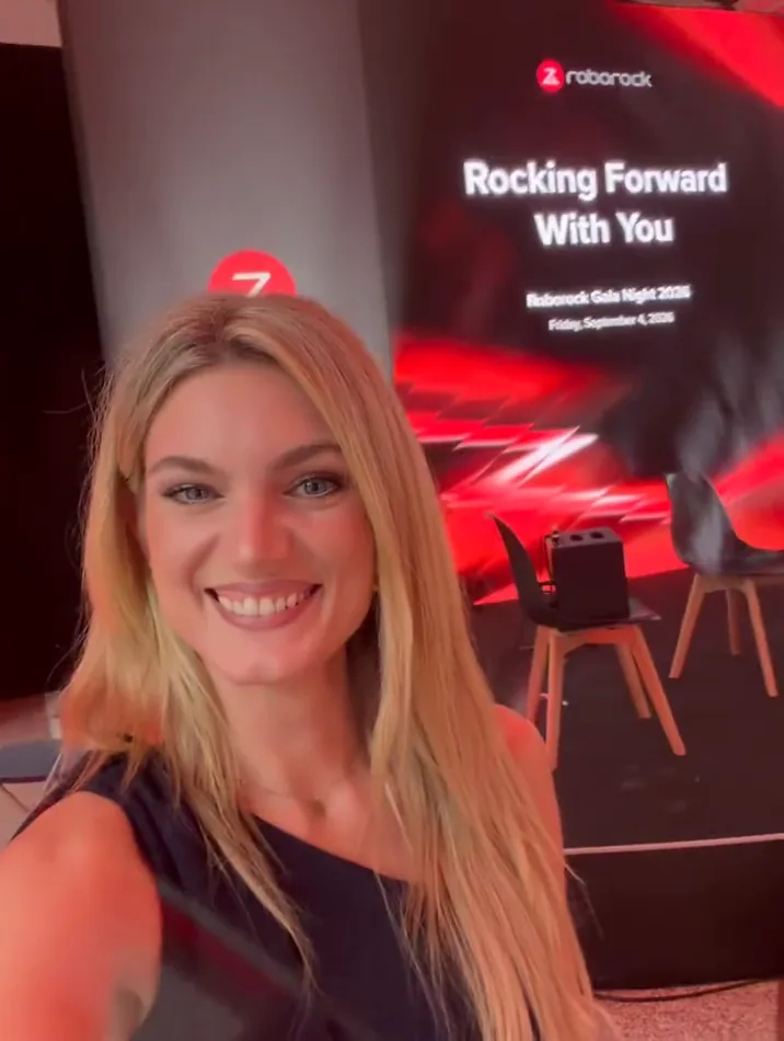 Moderatorin Kyra Baltrusch macht ein Selfie vor der Bühne mit der Roborock-Leinwand Rocking Forward With You