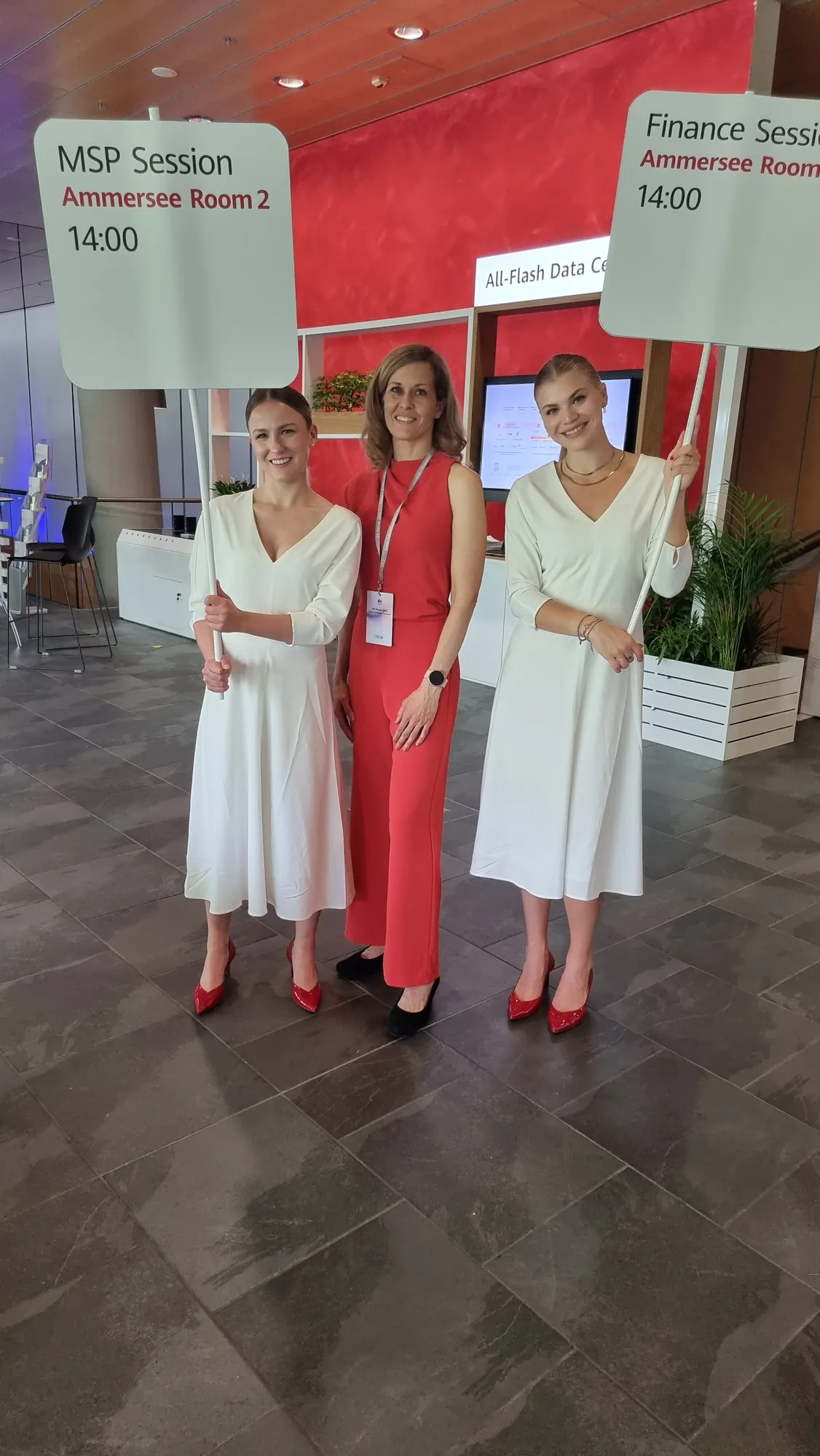 Two hostesses in white dresses holding session signposts at the Huawei IDI Forum 2022 | eventas