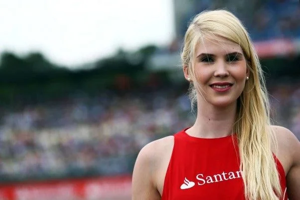Grid girl with the Santander logo on her red dress in front of the grandstand at the Hockenheimring