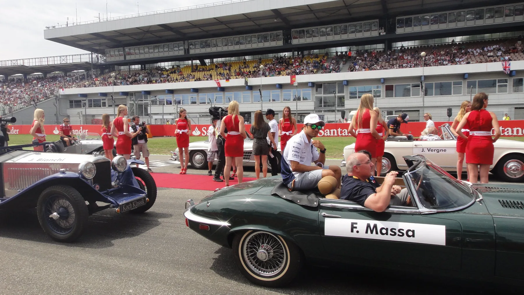 Driver parade with classic cars at the Hockenheimring, with grid girls in red Santander dresses behind them