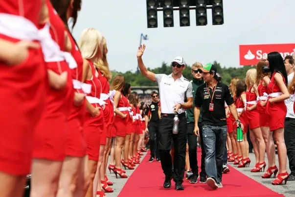 Driver waving during the driver parade between two rows of grid girls on the red carpet in Hockenheim