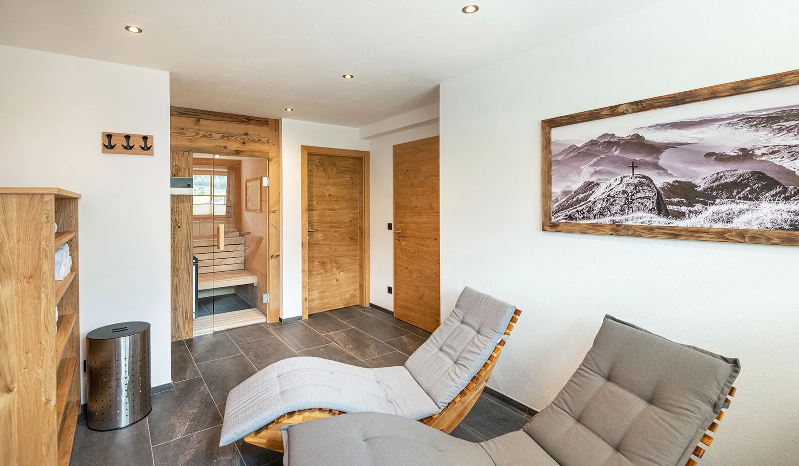 Chalet wellness relaxation room with wooden loungers and a framed mountain photo