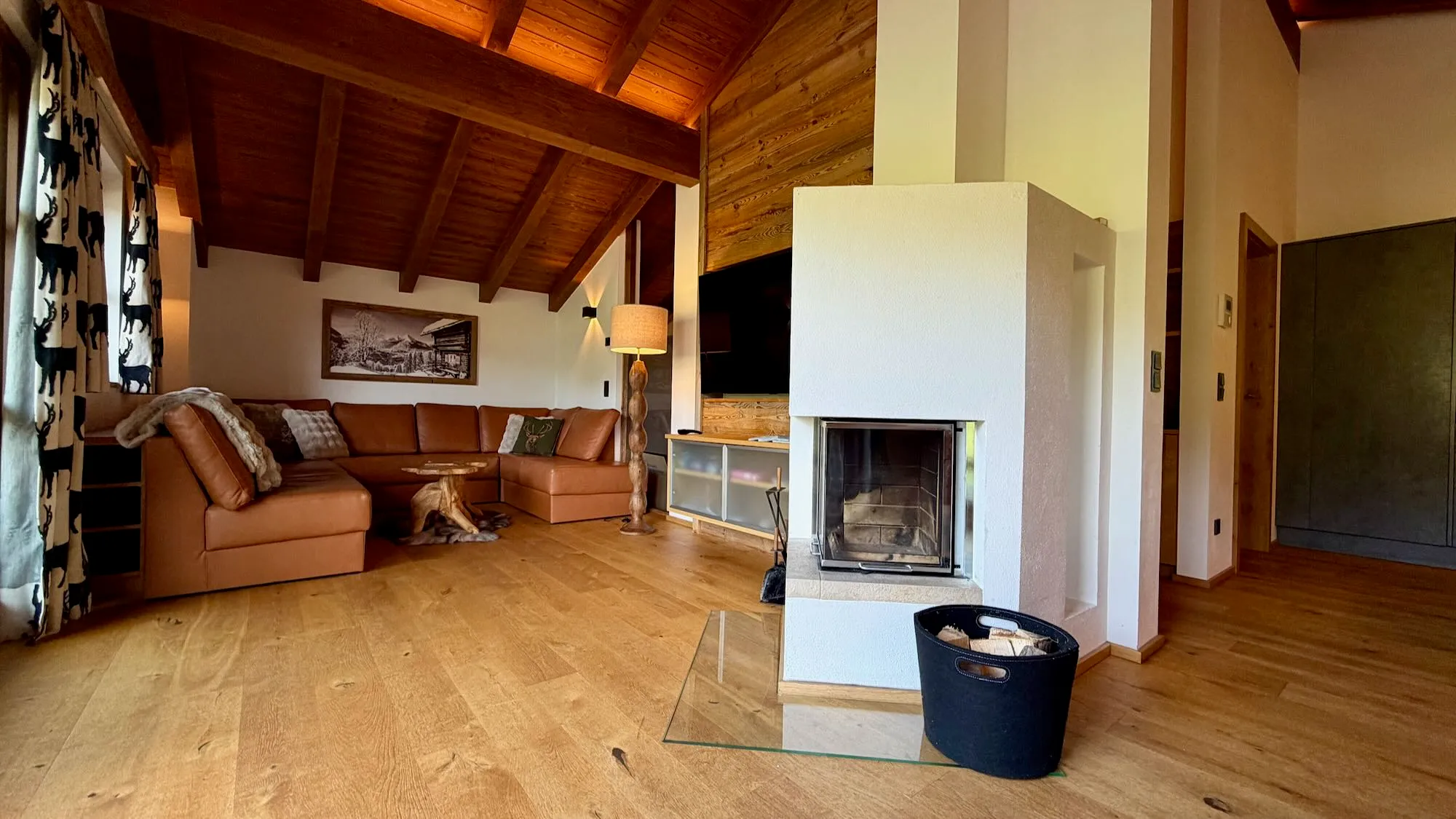 Cosy chalet living room with a modern fireplace, sofas and warm wooden interior