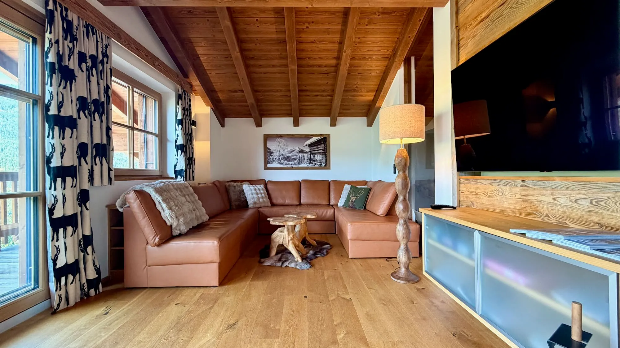 Cosy chalet lounge with a leather corner sofa, large flatscreen TV and fireplace for a bit of romance