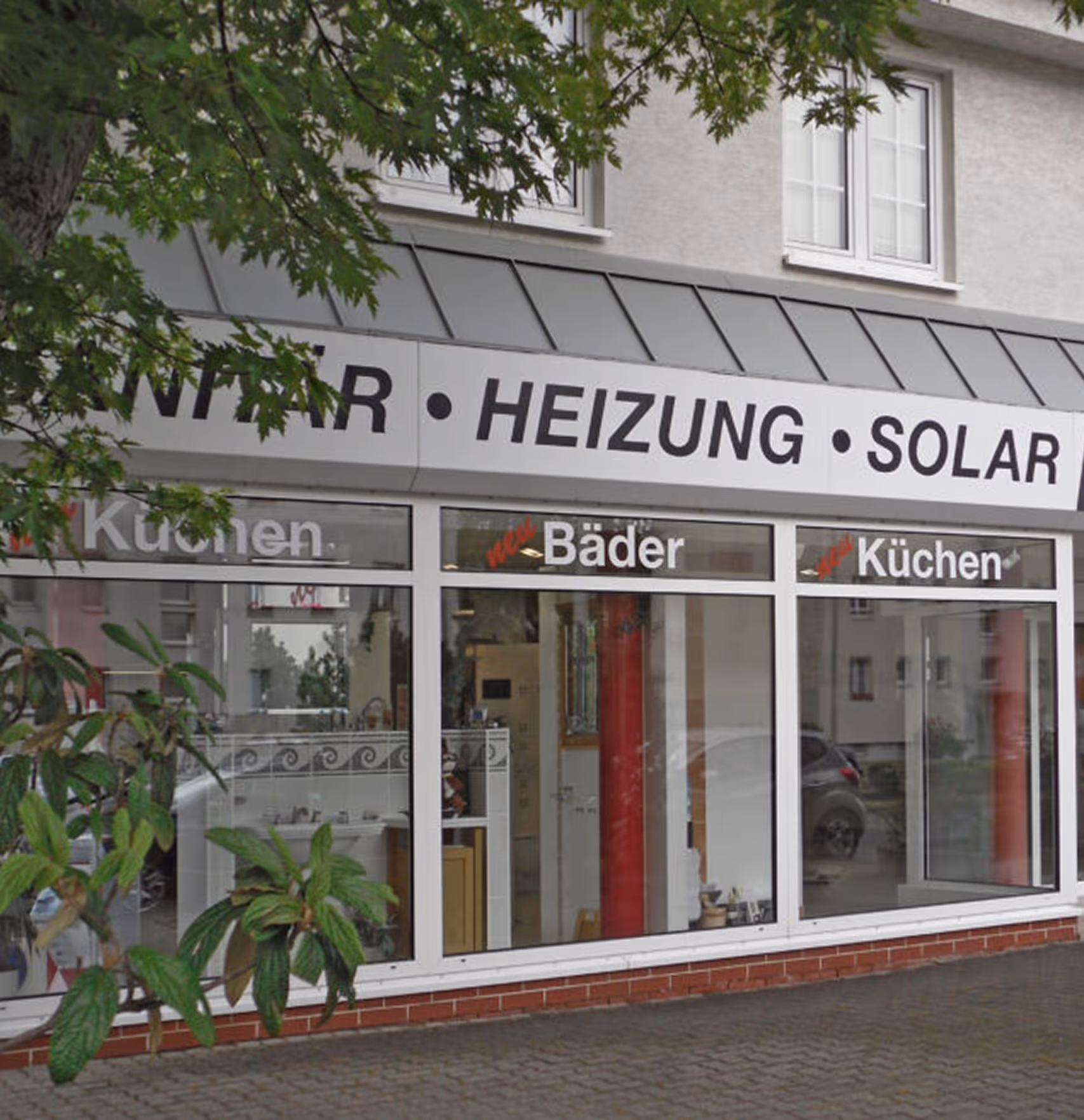 Ladenfront mit Werbung für Sanitär, Heizung, Solar, neue Bäder und Küchen.