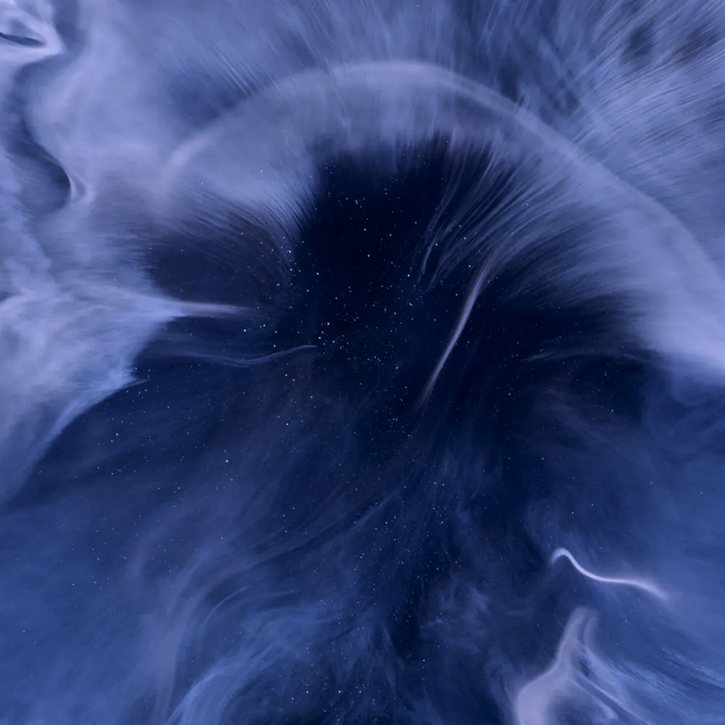 Swirling deep blue and black abstract space-like pattern with tiny star-like specks.