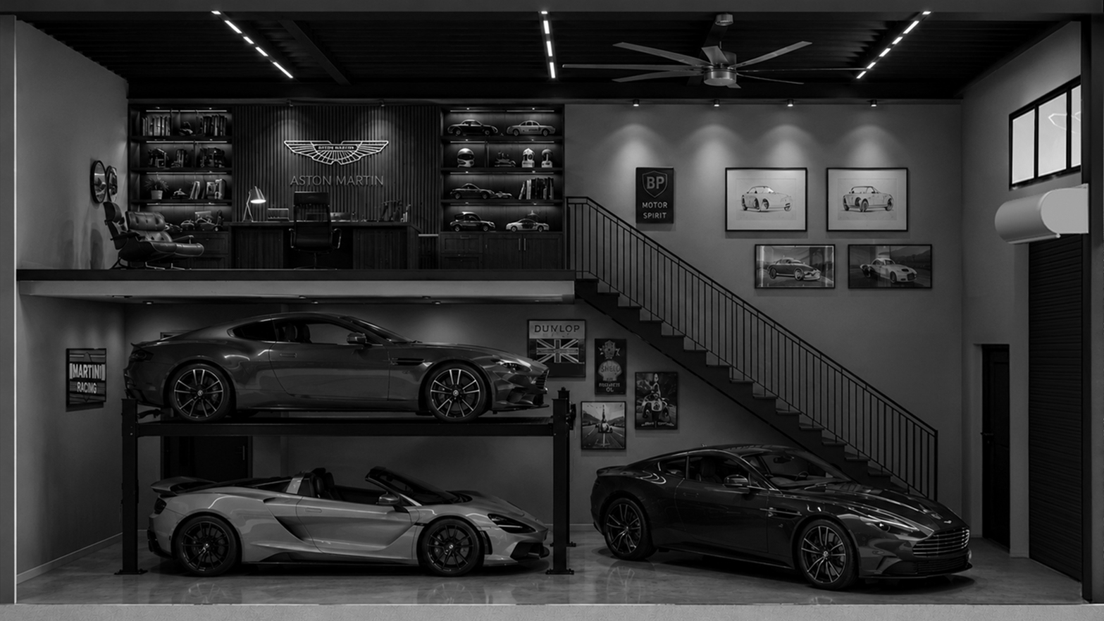 Luxury garage with three sports cars, a loft office with Aston Martin logo, and framed car photos.
