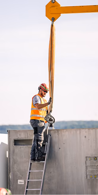 Handwerker bei Arbeiten mit einem Kran auf einer Baustelle