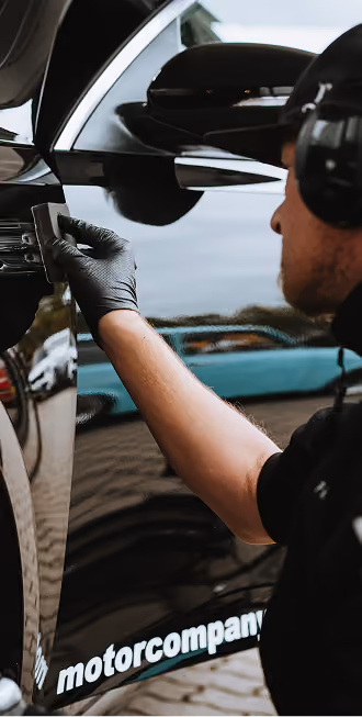 Kfz-Mechatroniker bei Arbeiten an einem Fahrzeug