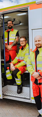 Team eines Rettungsdienstes gemeinsam am Einsatzfahrzeug