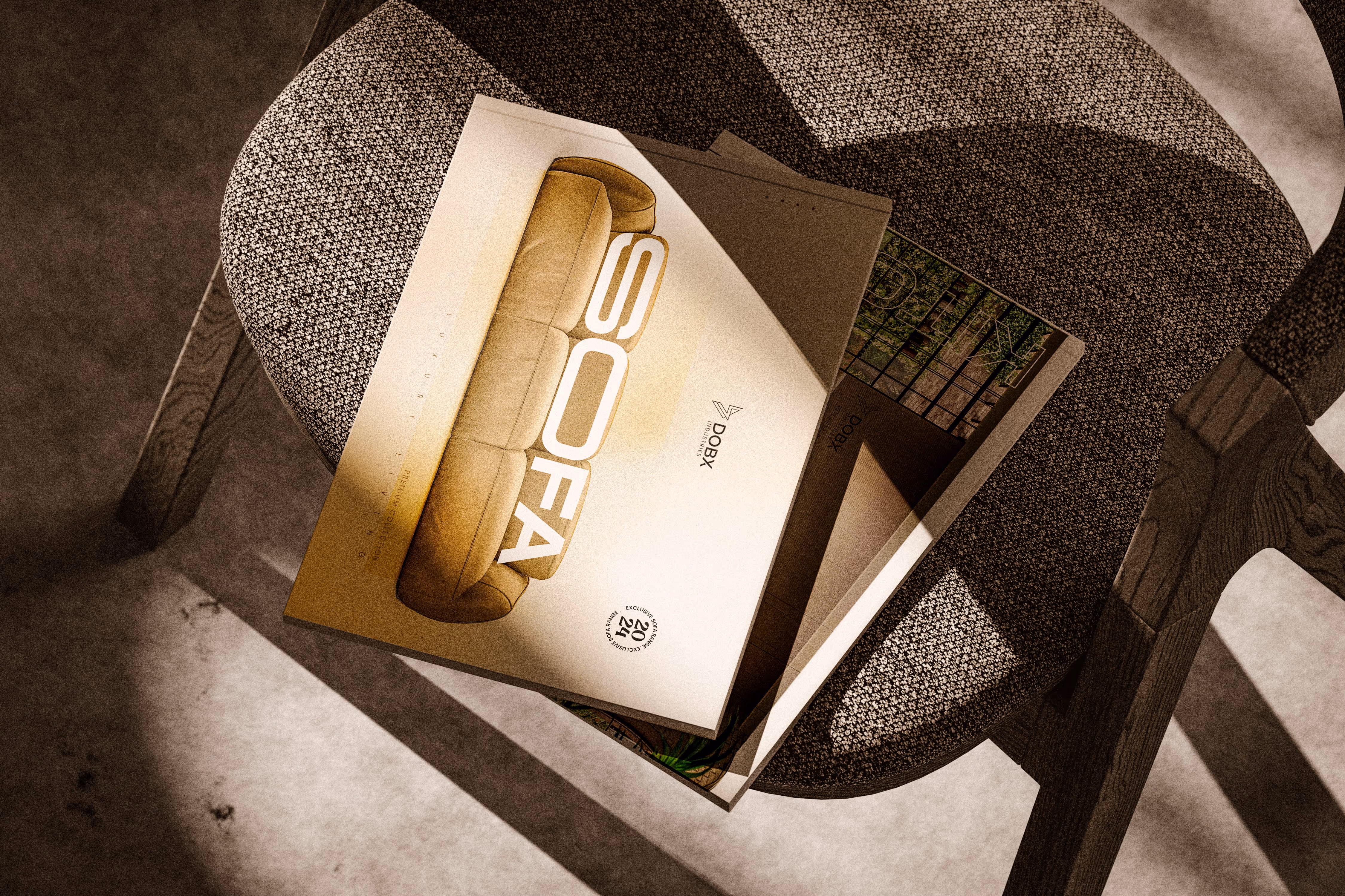 Stack of brochures on a textured chair seat, top brochure shows an image of a sofa and text SOFA.
