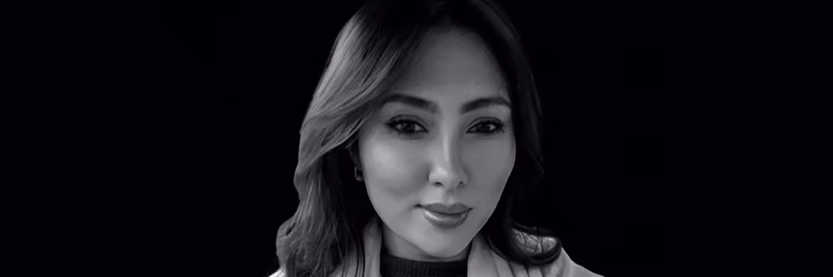 Black and white portrait of a woman with long hair against a dark background.