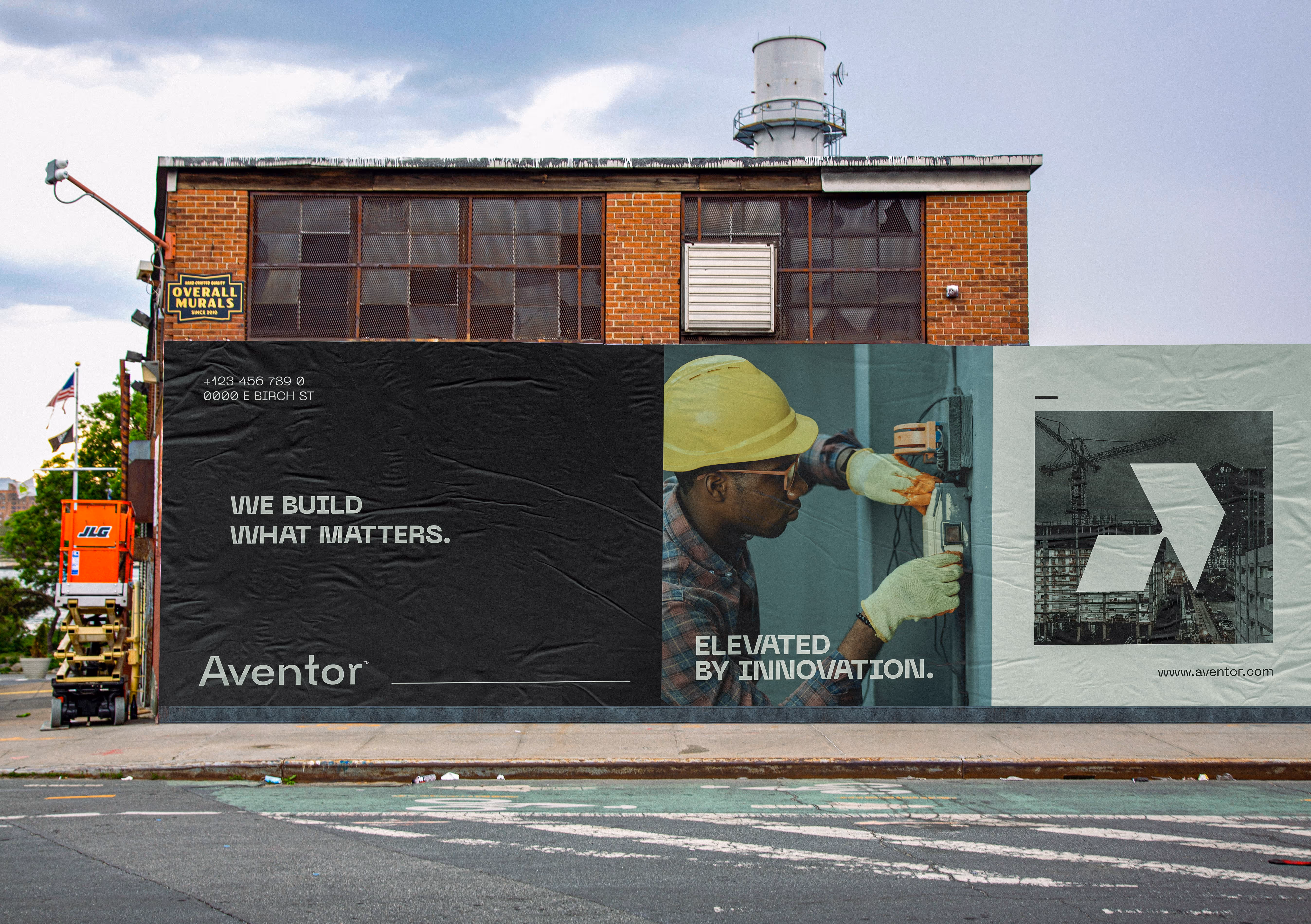 Brick building with a mural showing a worker in a hard hat, text 'We build what matters', and a logo.