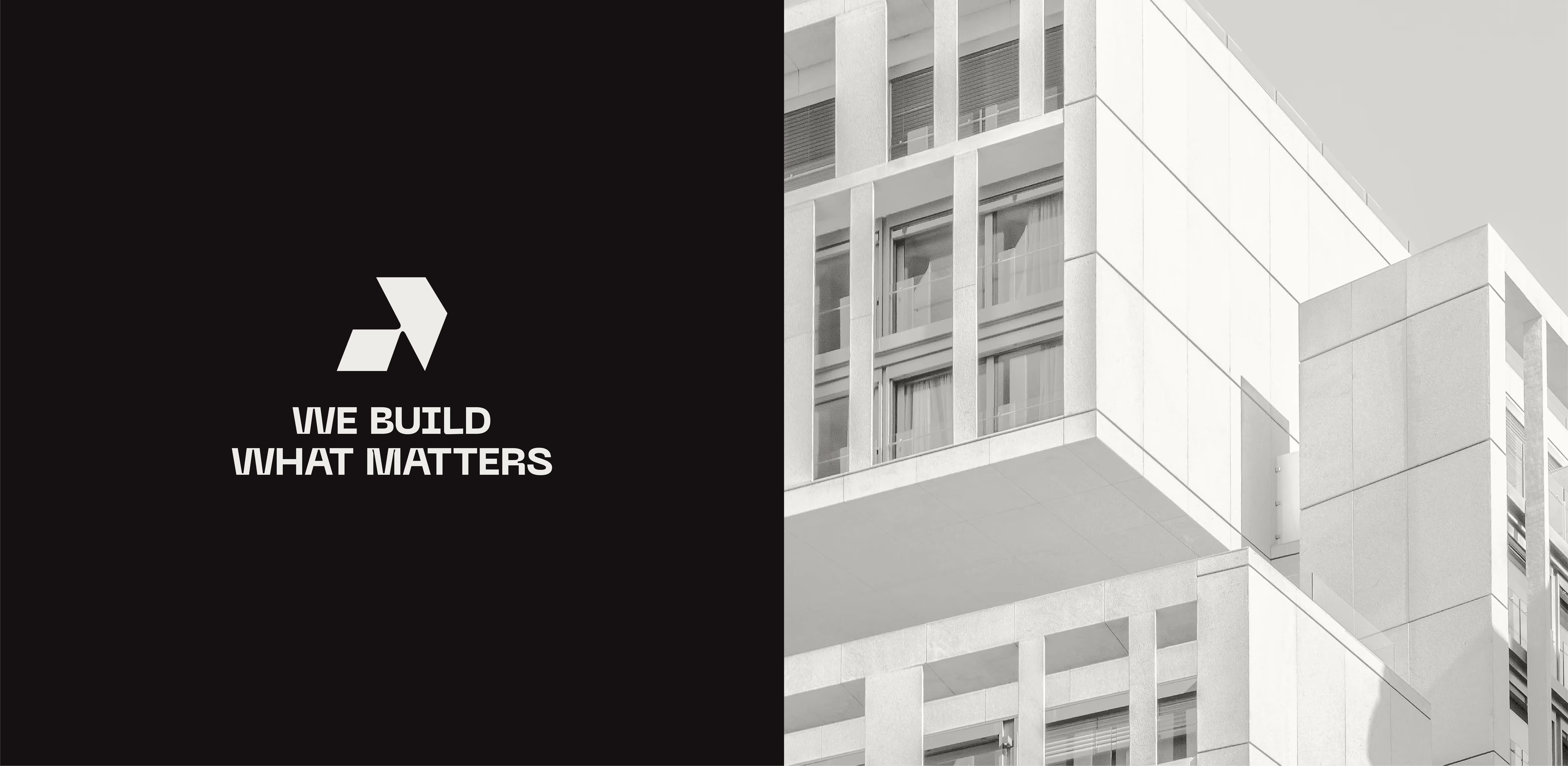 Modern white building with large windows beside a black panel with text and geometric logo.