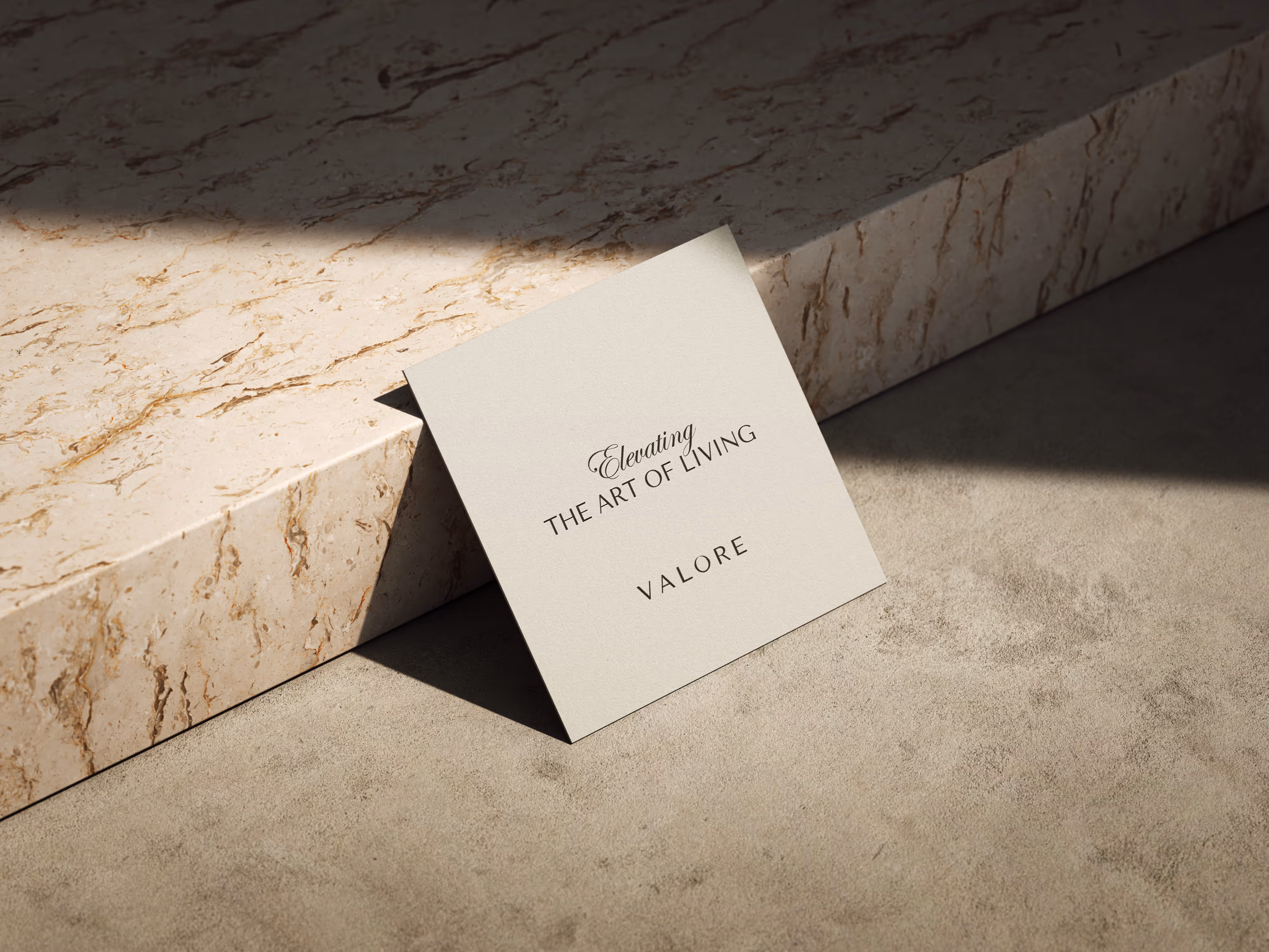 Card leaning against marble step with text: Elevating the Art of Living, VALORE in black on beige card.