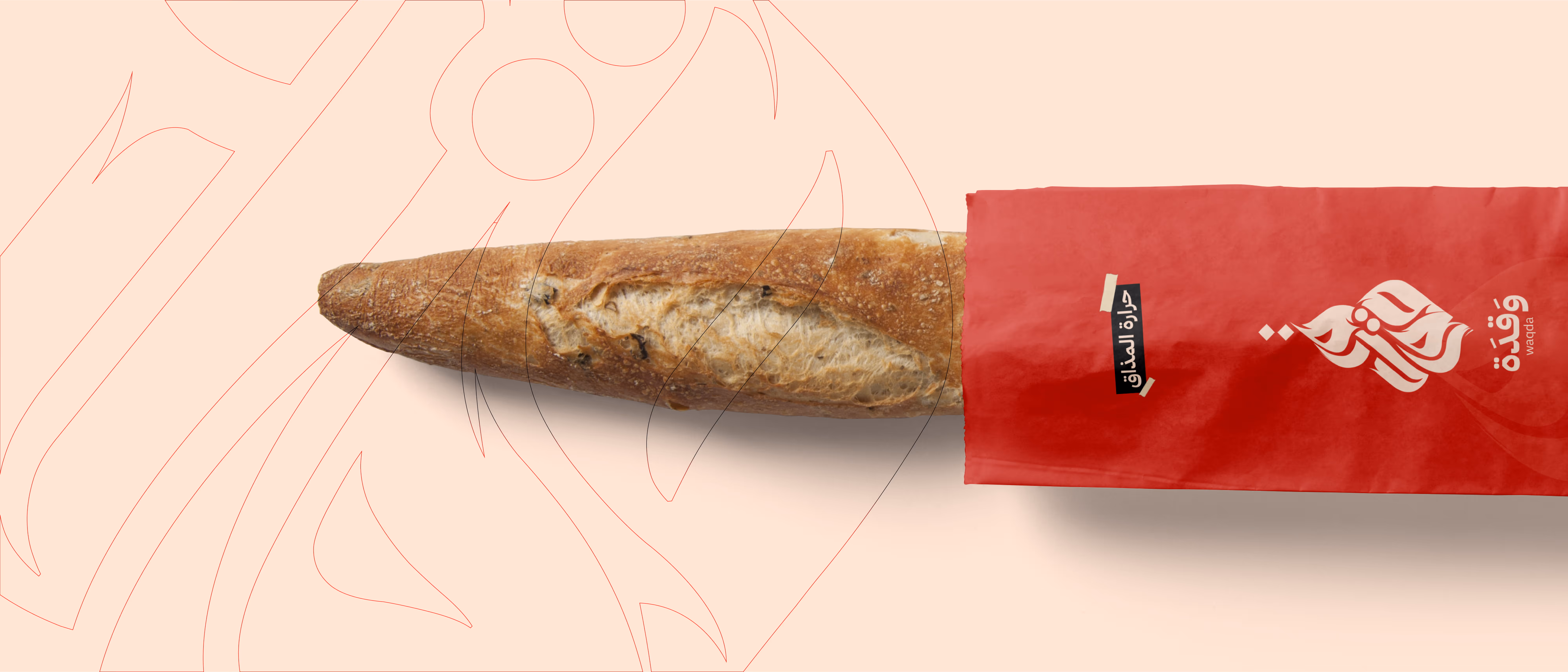 Long baguette bread partially wrapped in a red bag with Arabic text on a light background.