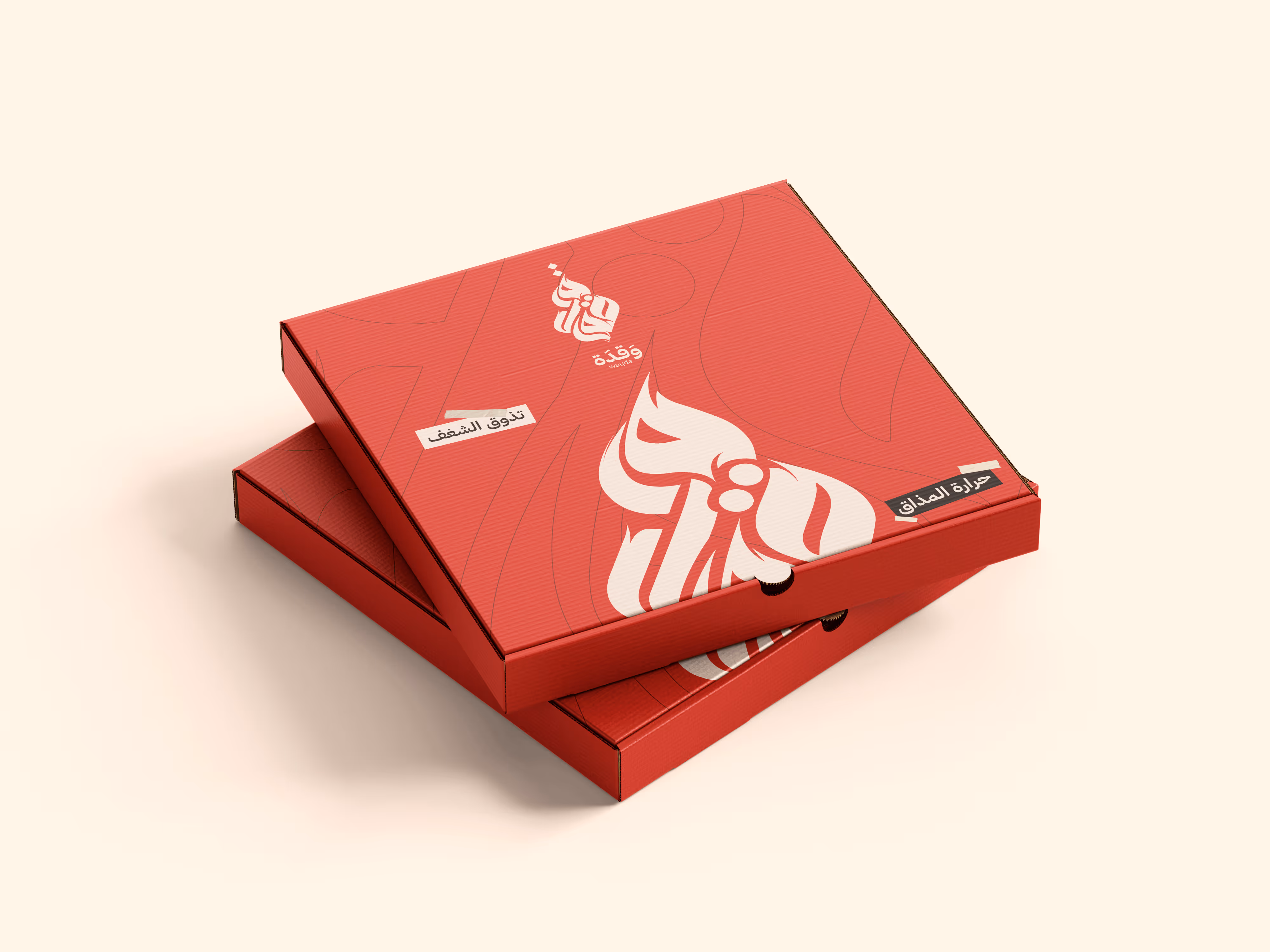 Two stacked red pizza boxes with Arabic calligraphy and logos on a light background.