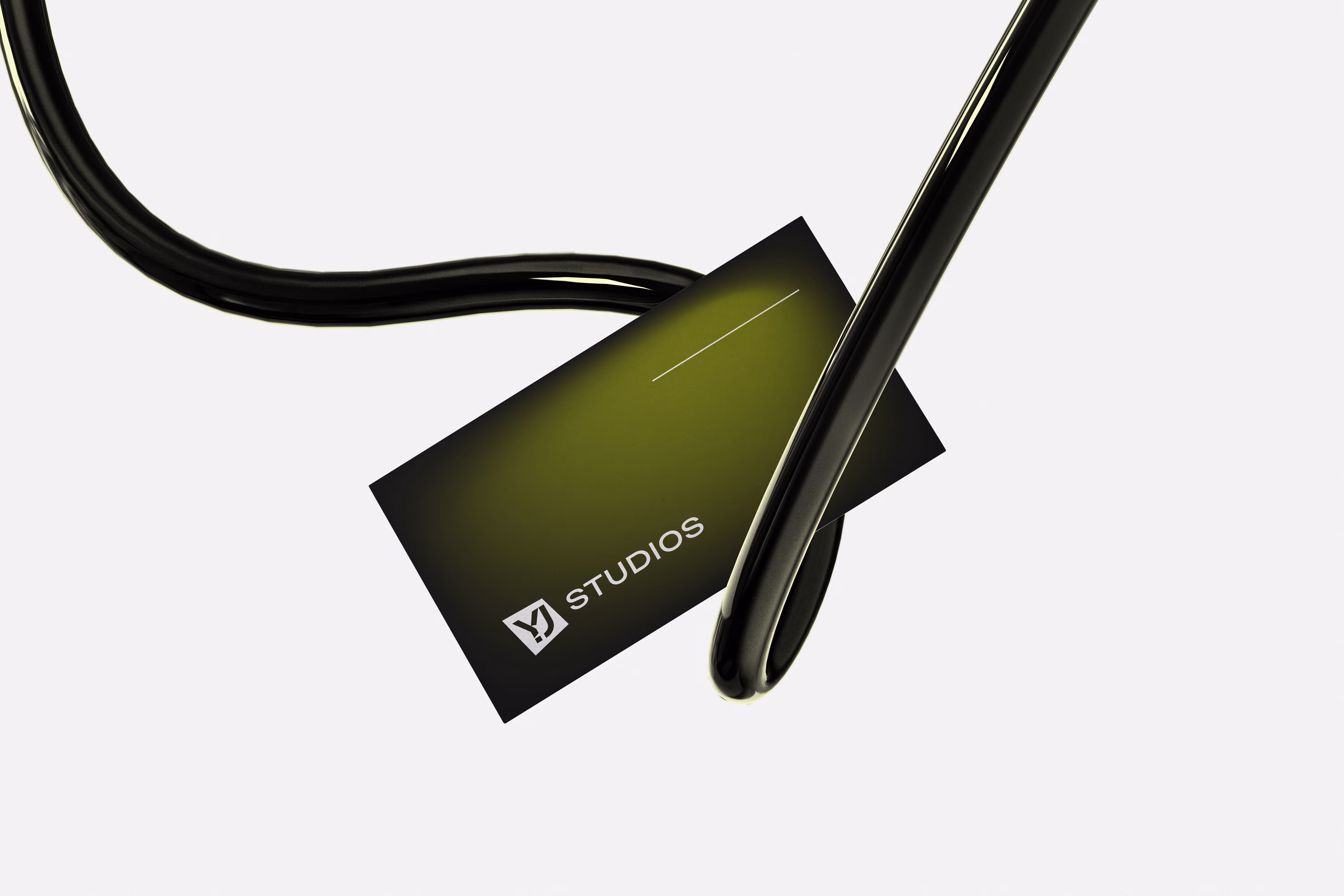 Green and black business card with YJ Studios logo, twisted black cables around it on white background.