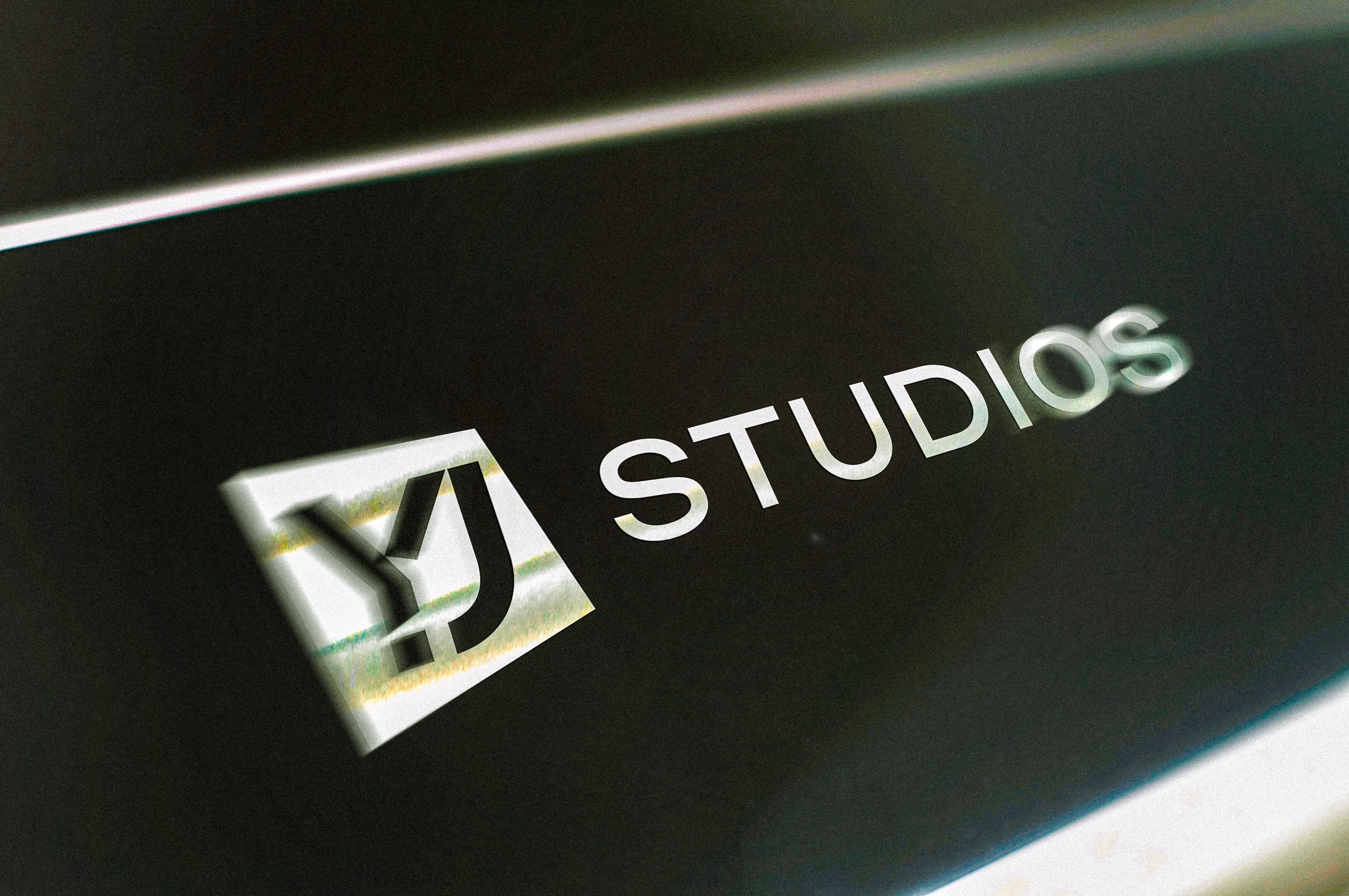Logo with stylized Y and J letters beside the word STUDIOS on a dark background.