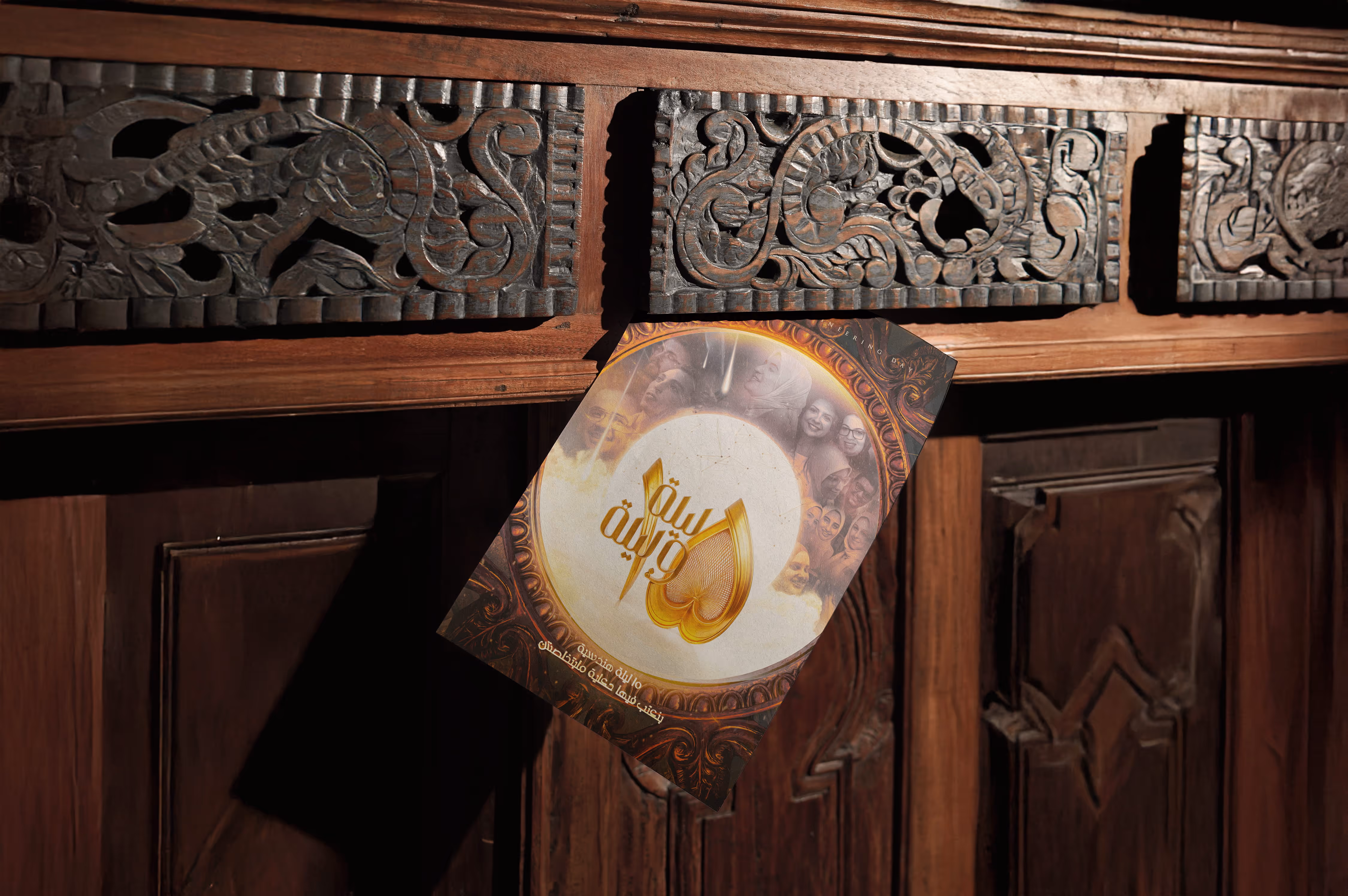 Arabic book with gold emblem and faces on cover resting against intricately carved dark wooden panels.
