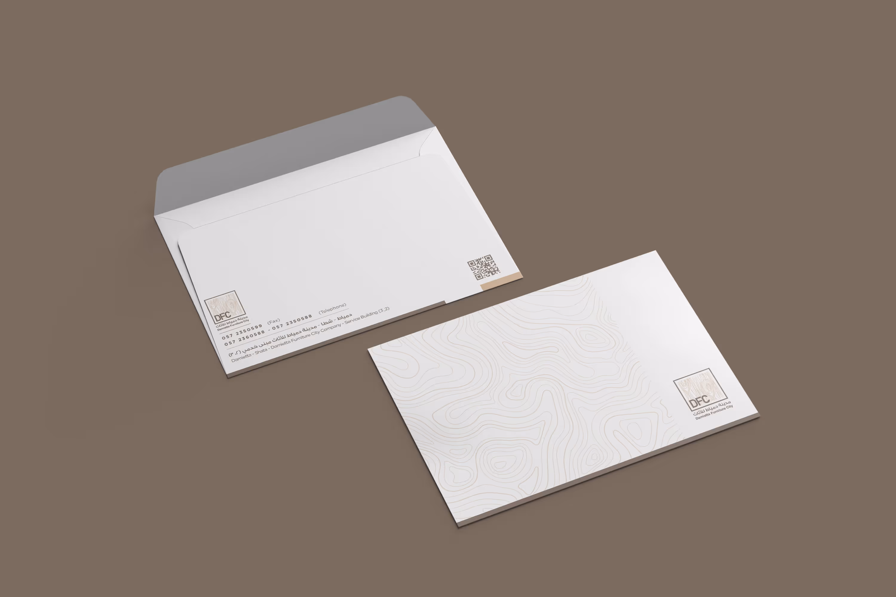 Two white envelopes with Damietta Furniture City logos and contact info on a brown background.