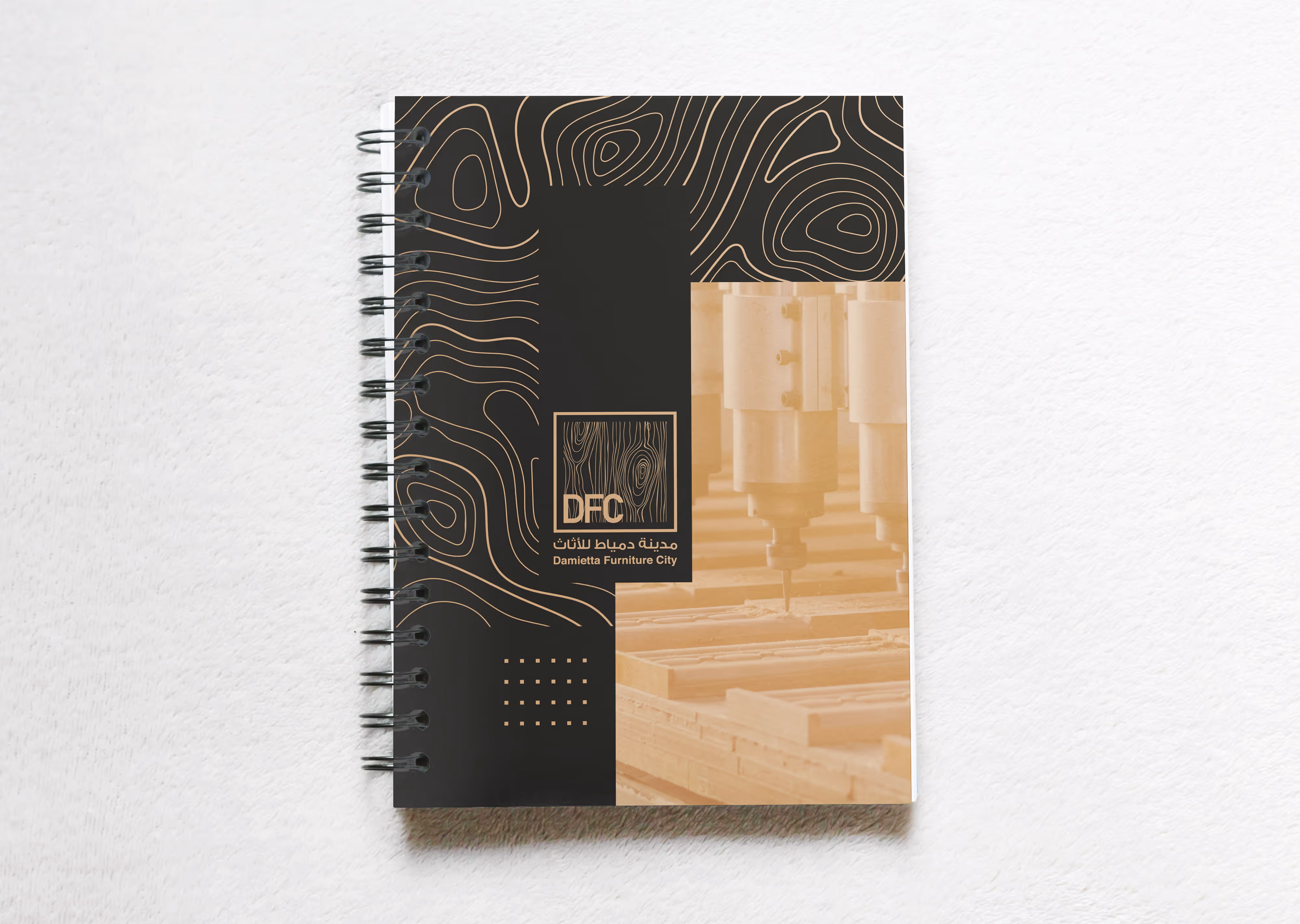 Spiral-bound notebook with Damietta Furniture City logo and wood engraving machine photo on cover.