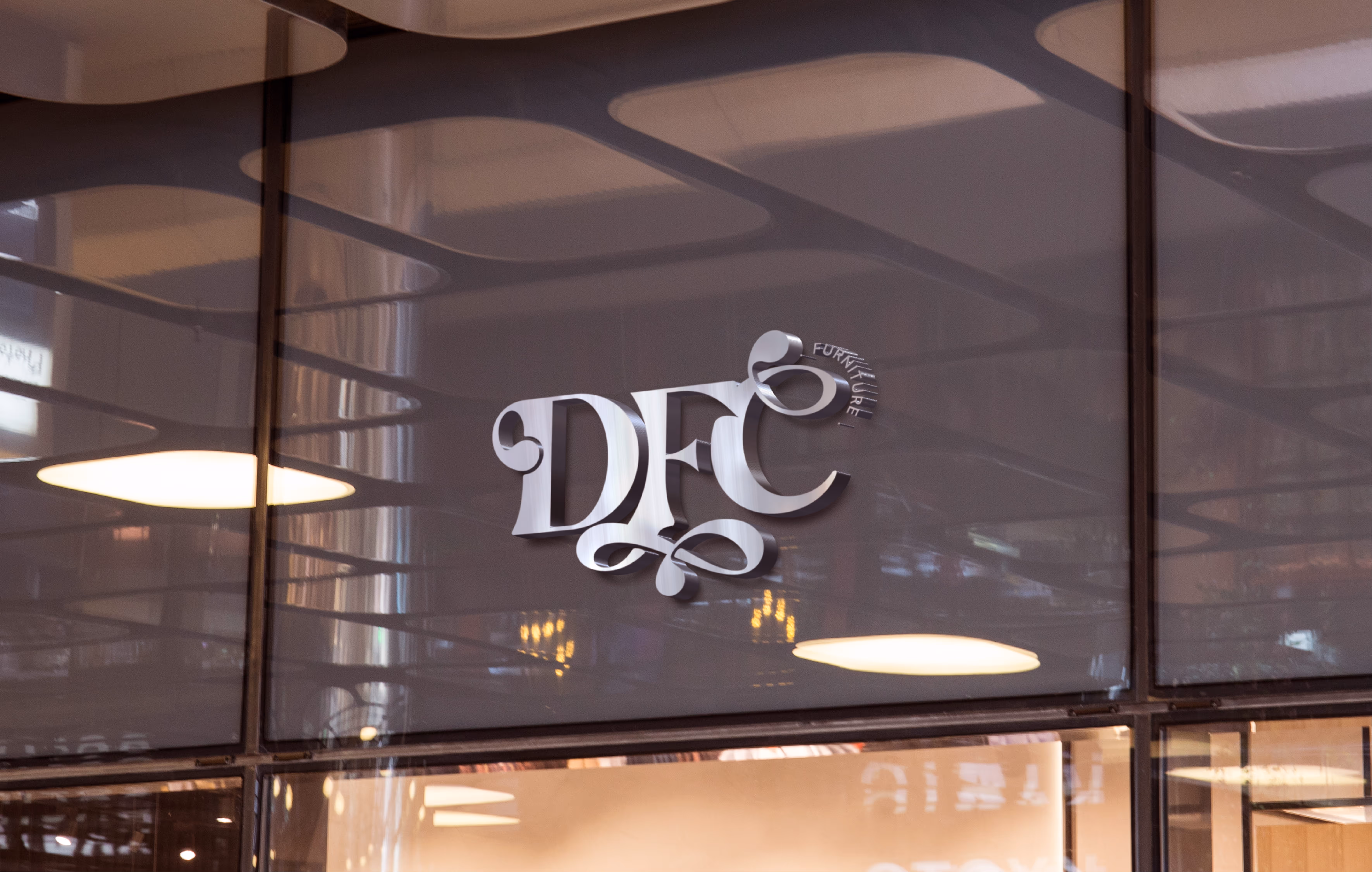Metallic sign with stylized letters DFC and the word furniture on a reflective glass wall.