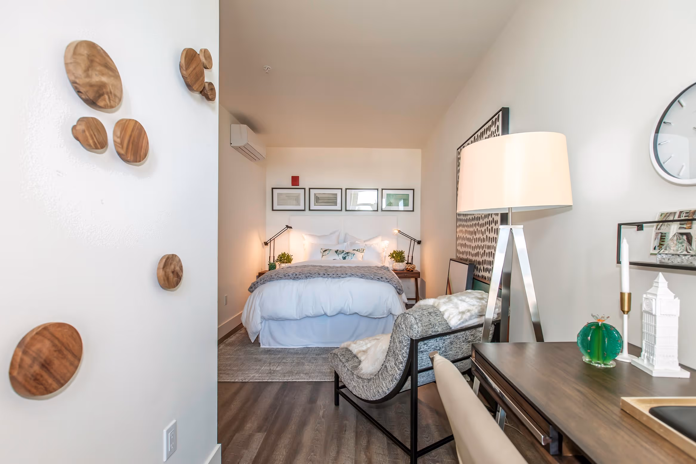 Hallway into furnished bedroom with decorative table, lamp, and bed