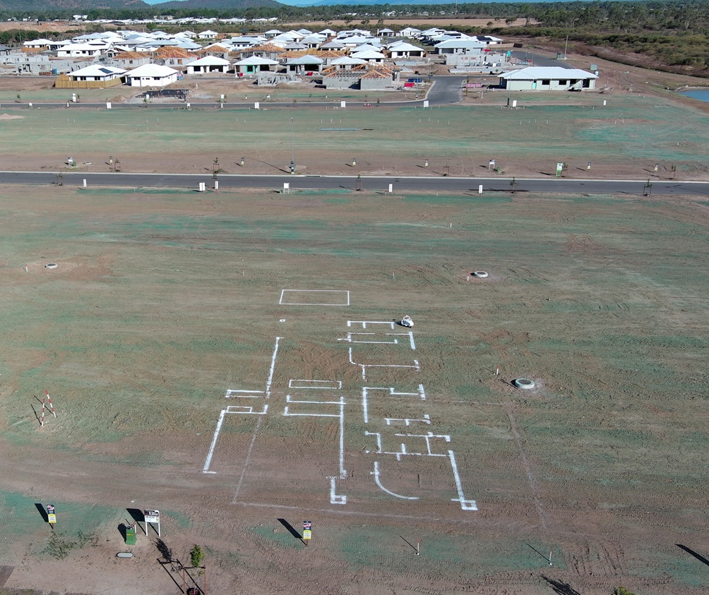 Aerial view of a full-scale house layout marked on a vacant North Queensland block.