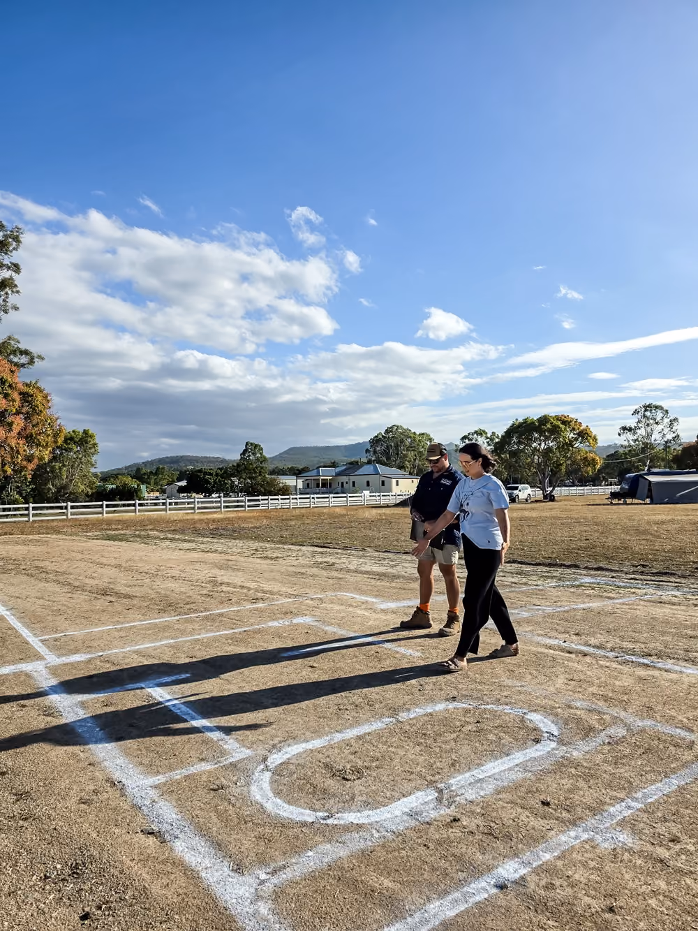 People walking through a full-scale house layout marked on a rural North Queensland block.
