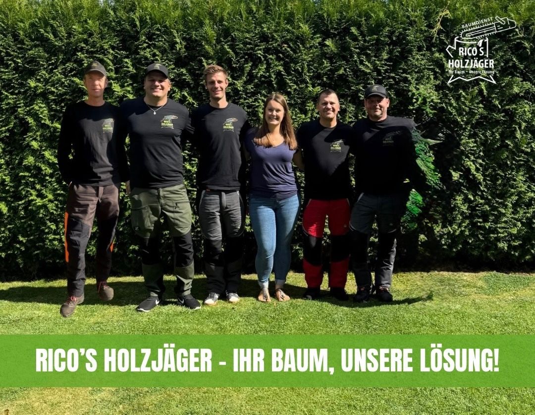 Sechs Personen stehen vor einer grünen Hecke, fünf tragen schwarze Shirts mit Firmenlogo.