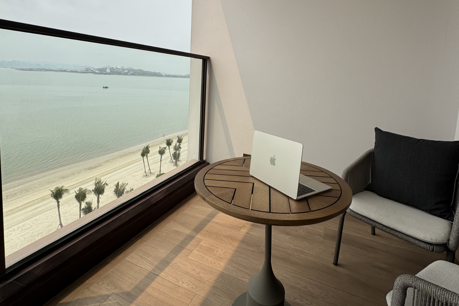 Laptop on balcony desk overlooking Halong Bay from hotel room