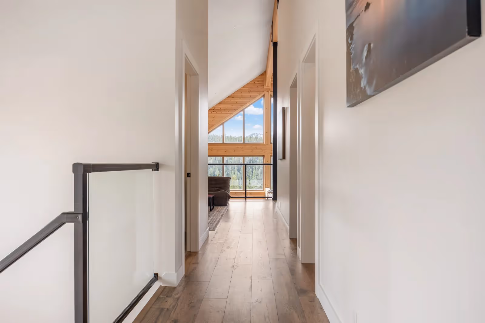 Open-concept living area of Fjellheim with floor-to-ceiling windows, A-frame architecture, and natural log warmth