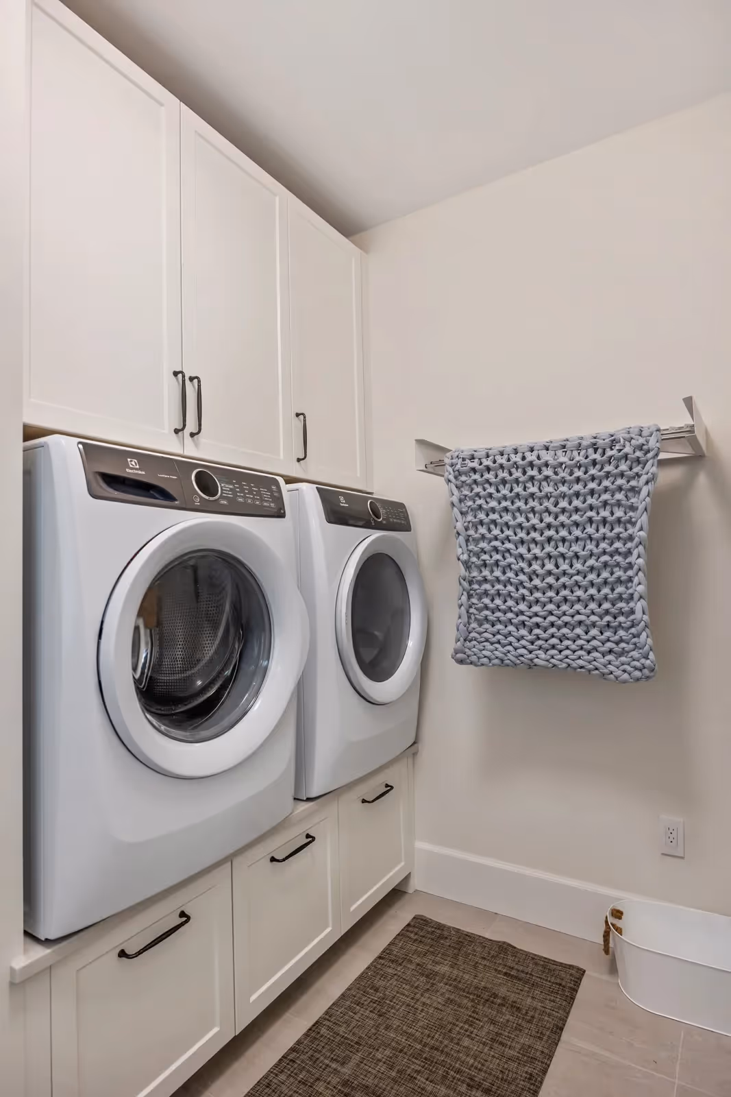 Custom built-in laundry suite with cabinetry storage in Misty Bluff home