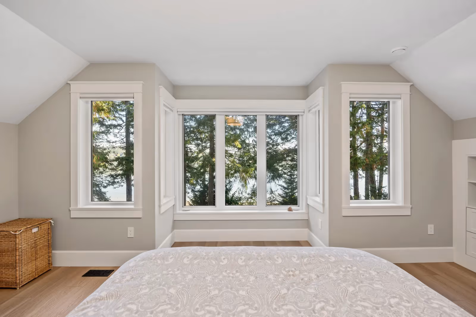 Light-filled bedroom in Misty Bluff with views of the surrounding forest and nature-inspired west coast design