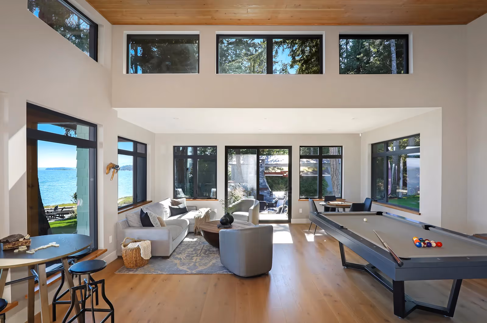 Coastal games room in Coastal Point with floor-to-ceiling wine cabinets and expansive coastal views