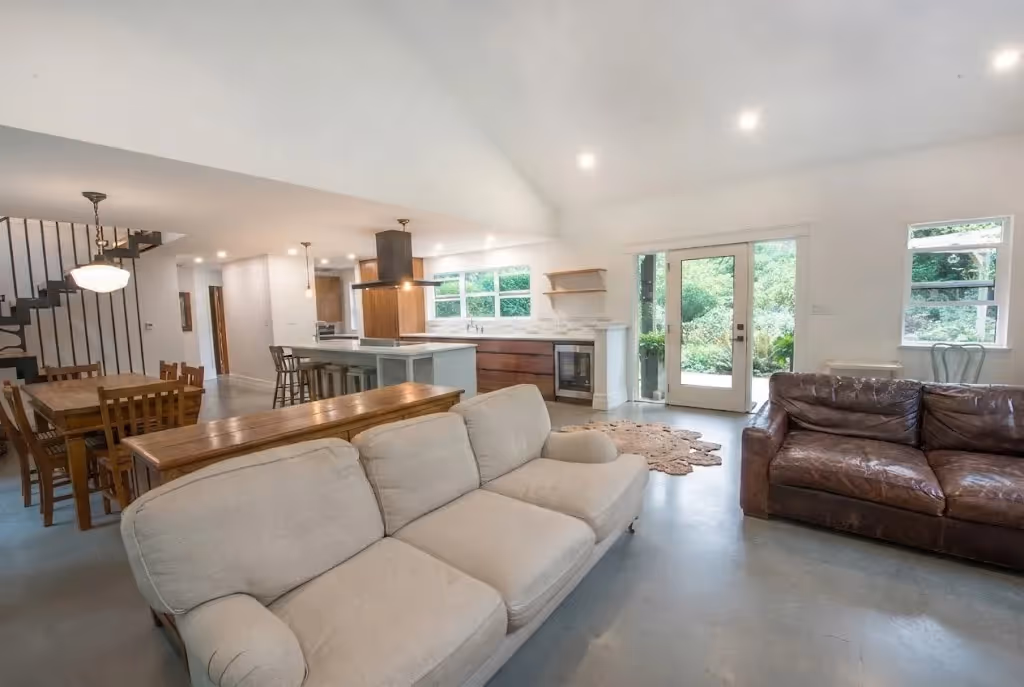 Polished concrete living room floors and high-contrast fireplace in Garden of Eden west coast renovation