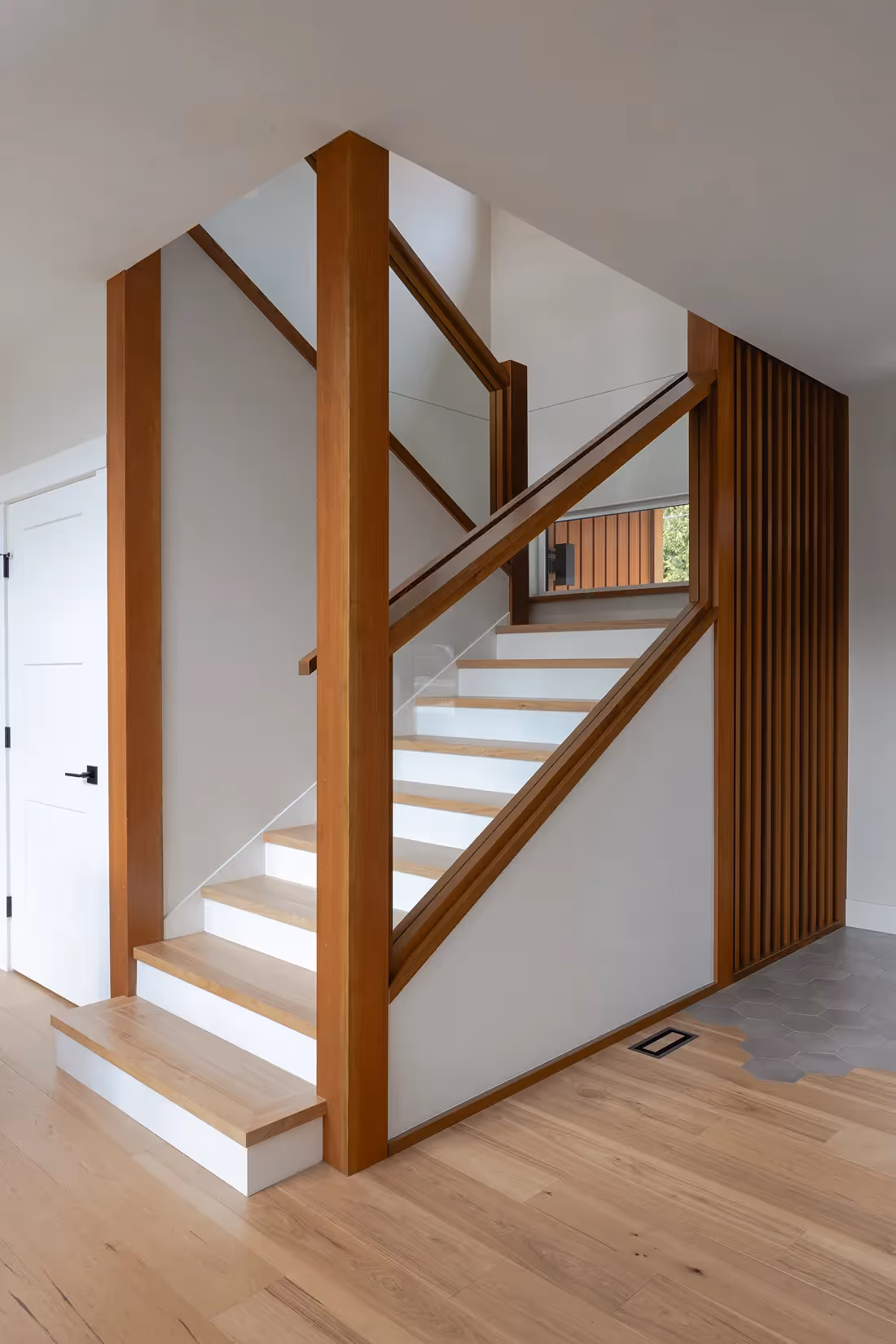 Custom built staircase with warm wood and clean lines in The Second Act Comox home