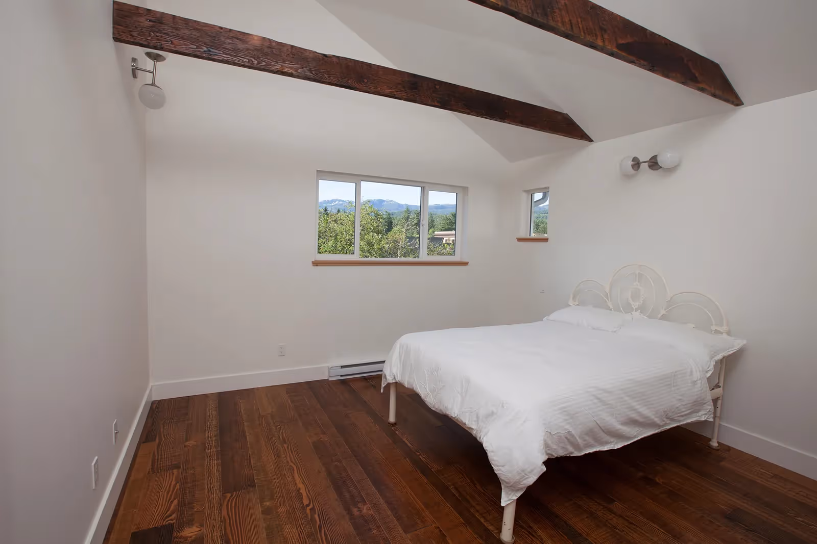 Bedroom with exposed timber beams in From the Ashes Cumberland rebuild adding rustic character and warmth