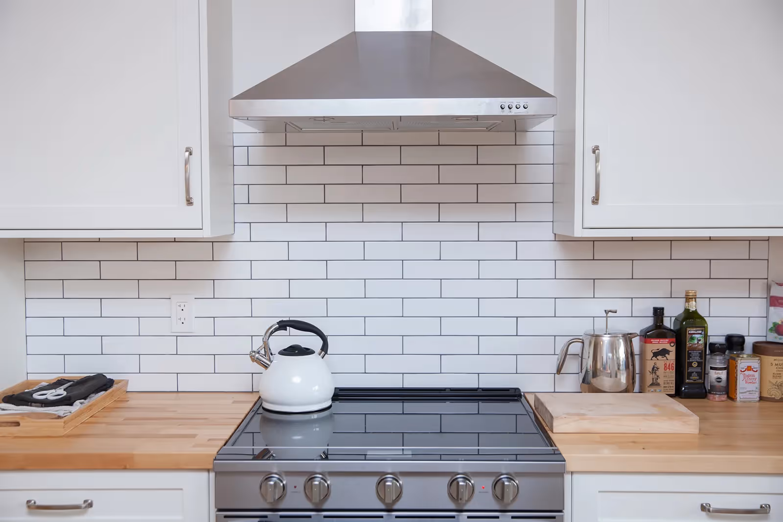 Butcher block kitchen countertop with contemporary shaker cabinetry in From the Ashes Cumberland home