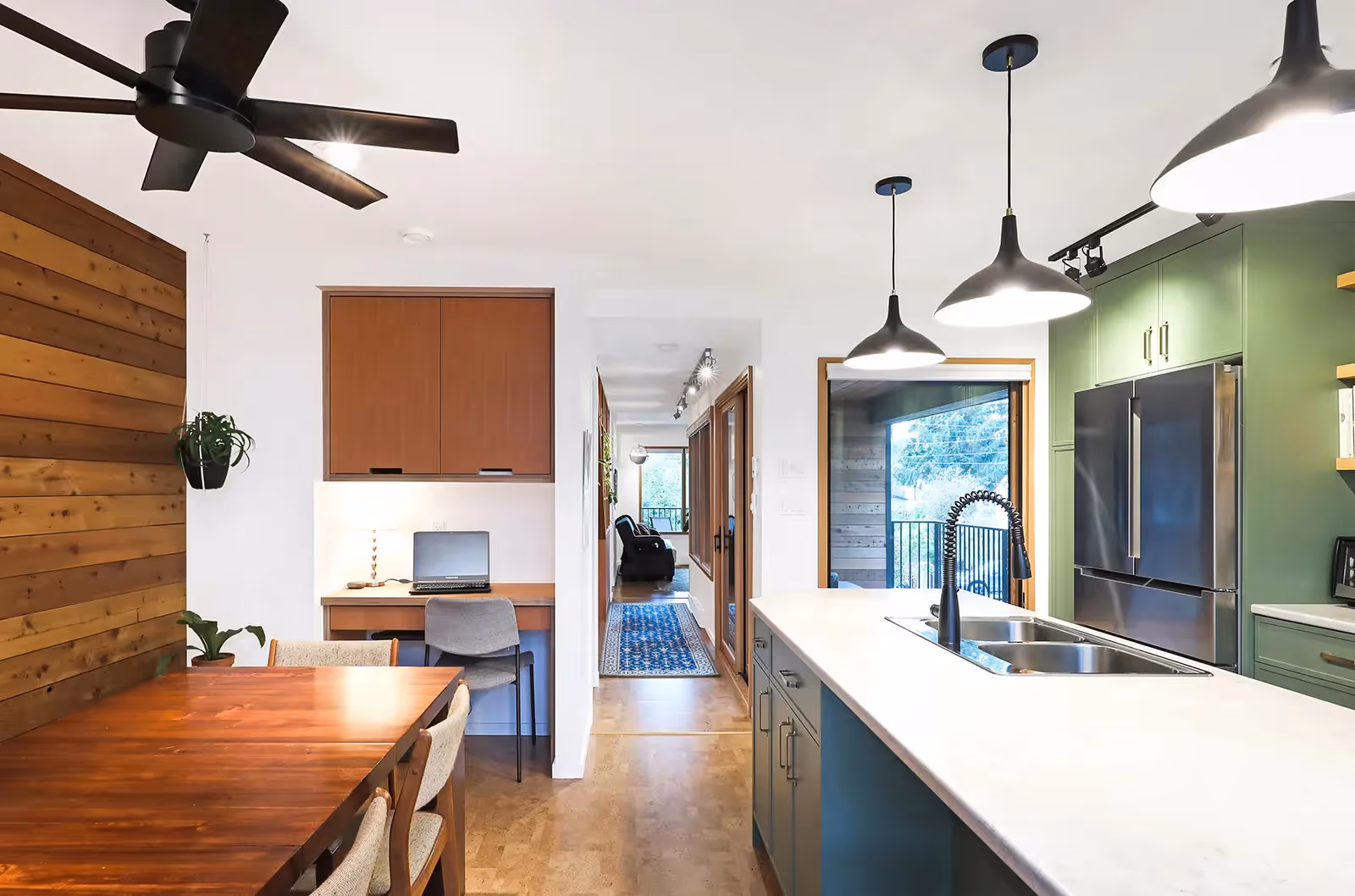 Vibrant green kitchen in Dark Side home with sleek modern cabinetry and mountain views through expansive windows