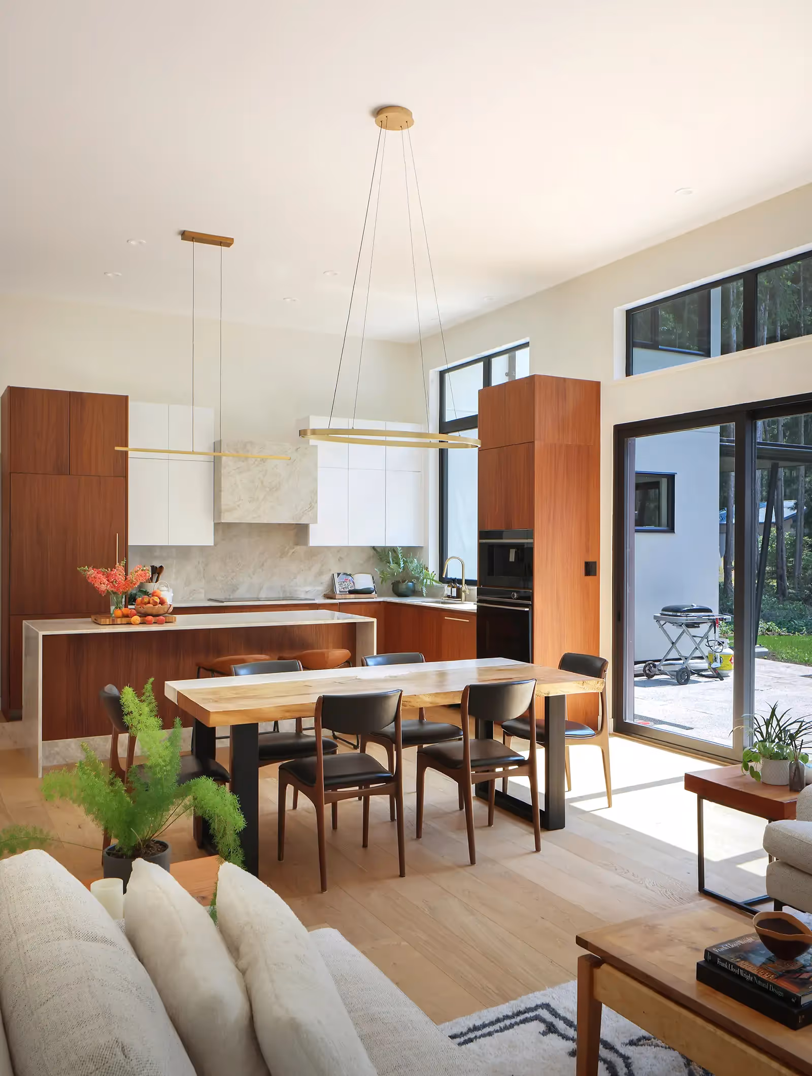 Light-filled open-concept living area in Pine Forest home with large windows framing forest views