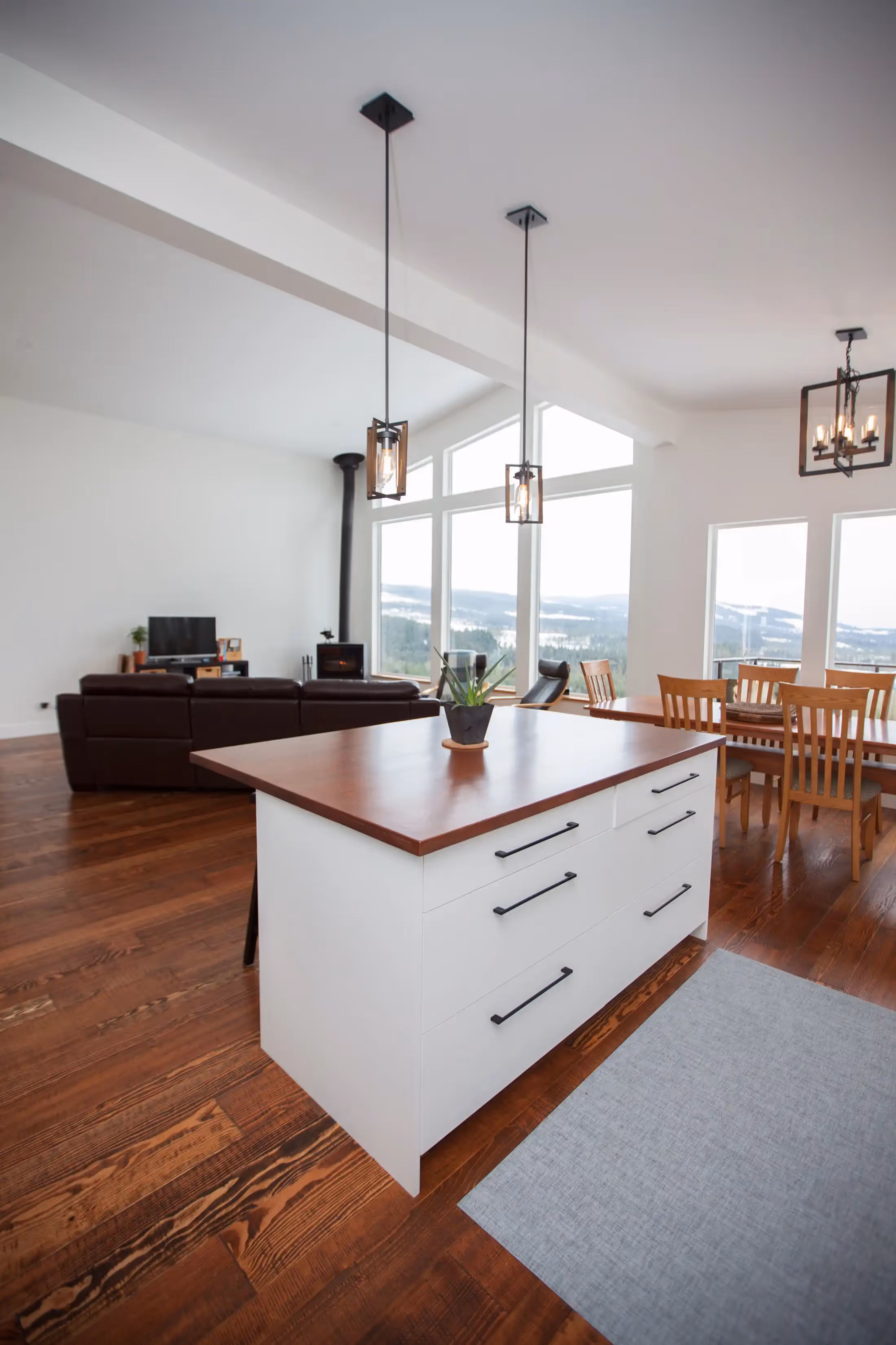 Open-concept living space in The Edge with built-in ski lift chair and floor-to-ceiling windows overlooking forest