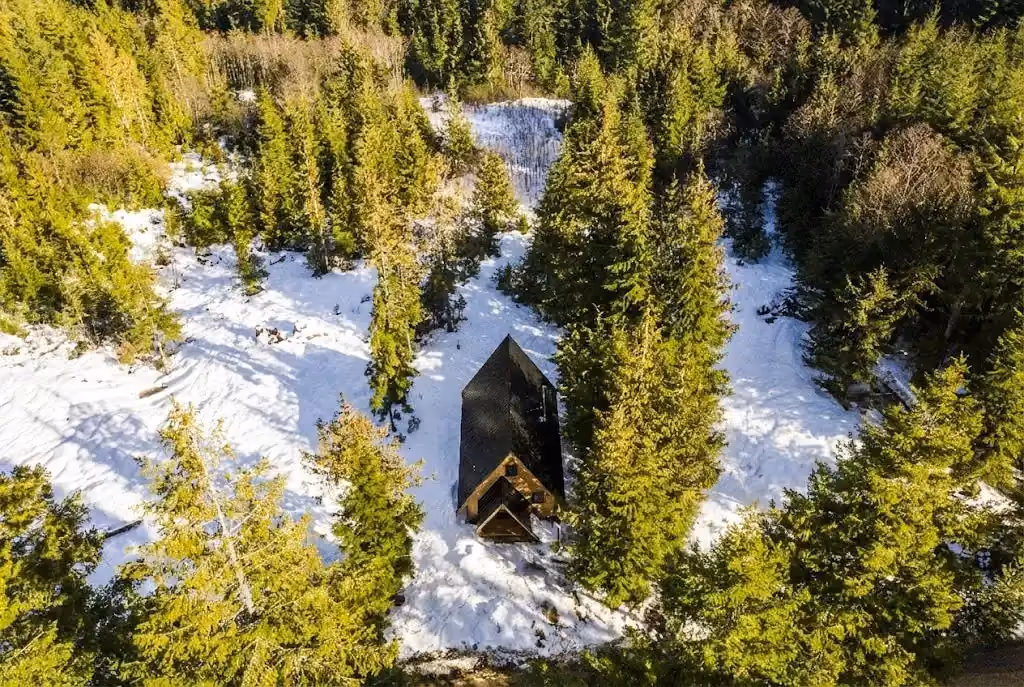 Interior detail of A Plus A-frame cabin with warm timber framing, woodstove, and industrial touches